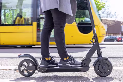 Trottinette qui passe à côté d'un tram Soléa